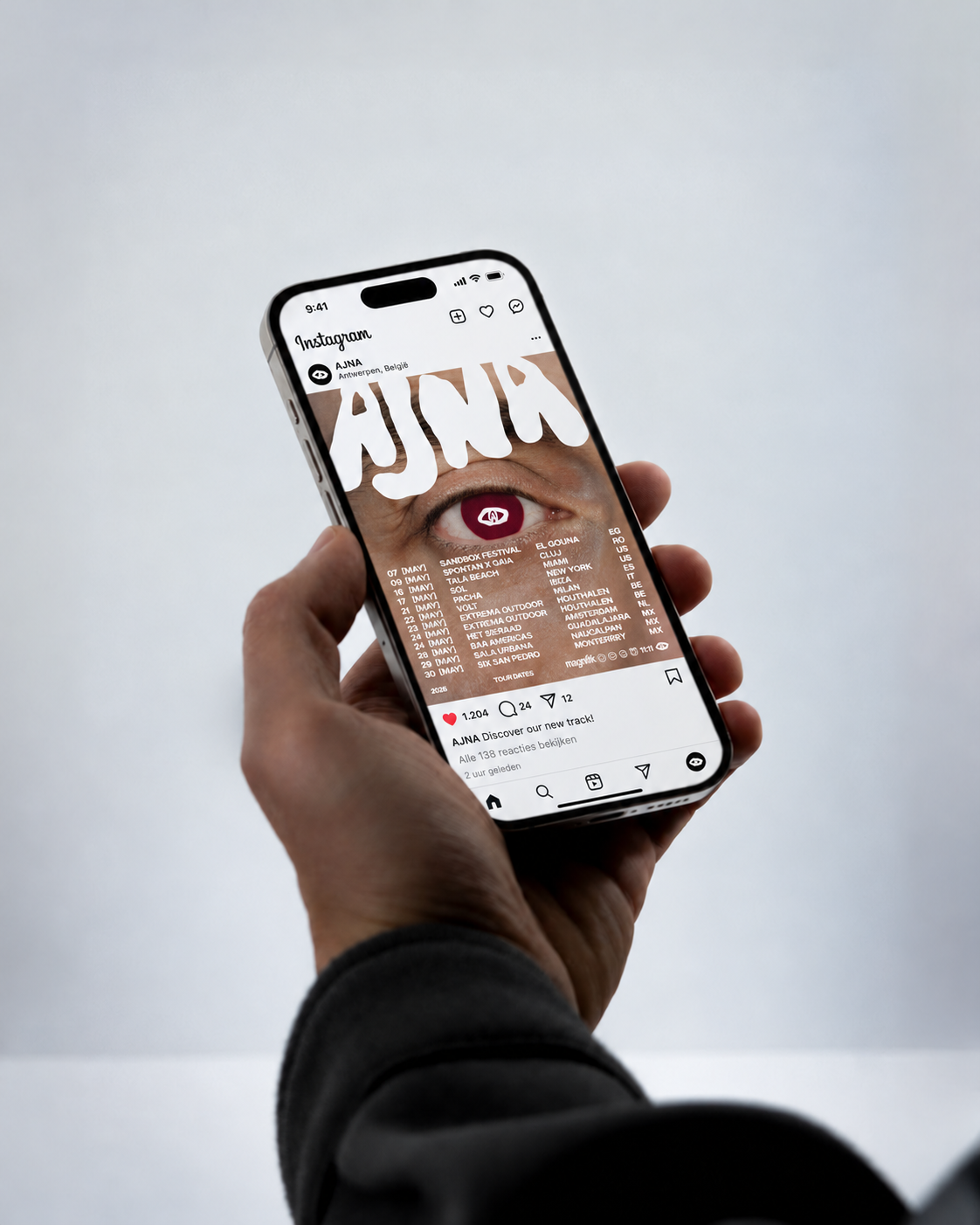 Hand met een iPhone waarop de AJNA-tourposter op Instagram te zien is