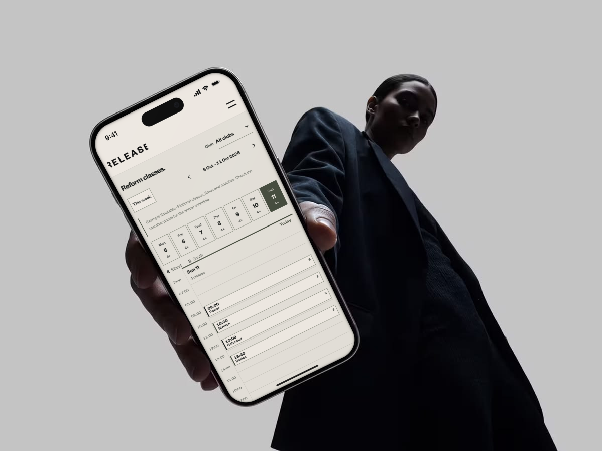 Persoon met een iPhone waarop het Reform-lessenrooster van het Release-websiteconcept te zien is